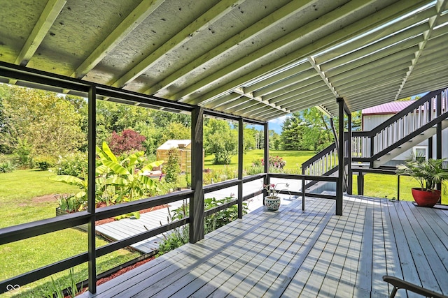 wooden deck featuring a lawn and stairway