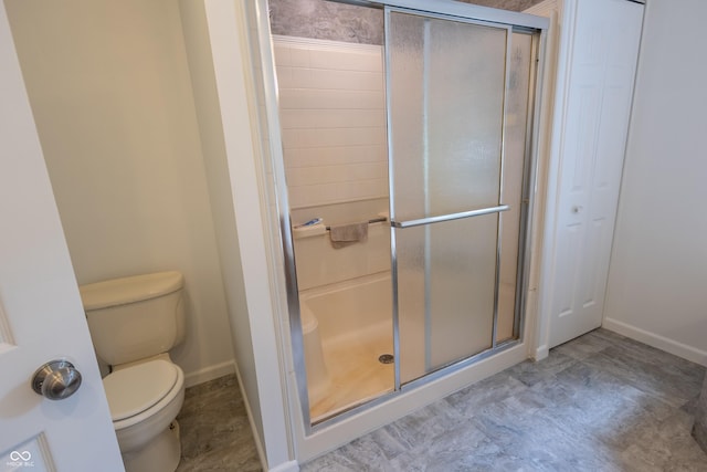 full bath featuring a stall shower, baseboards, and toilet