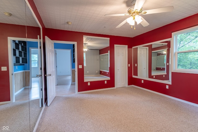 unfurnished bedroom with a ceiling fan, carpet flooring, and baseboards