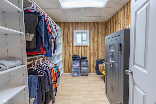 spacious closet with light wood-style flooring and a drop ceiling