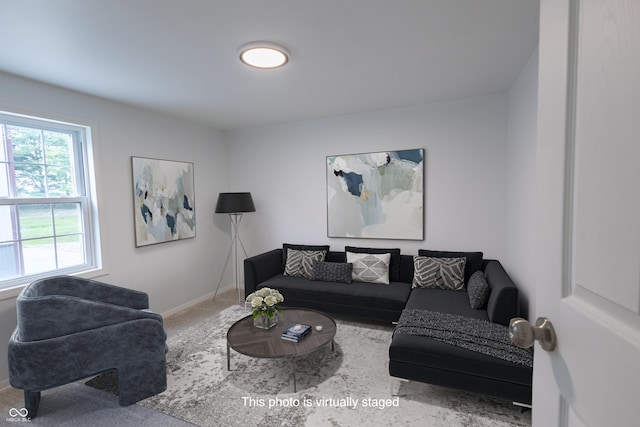 living area featuring carpet and baseboards