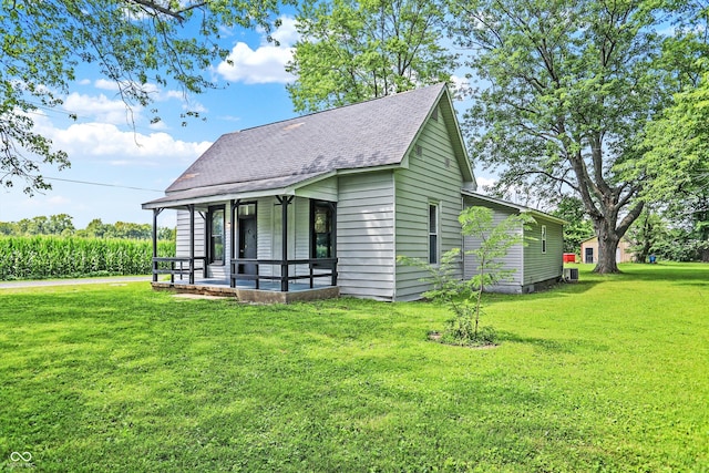 view of front of house featuring a shingled roof and a front yard