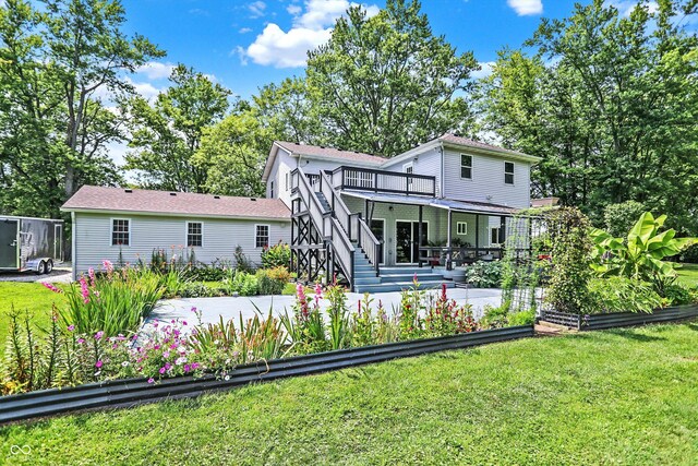 back of house with a deck and a lawn