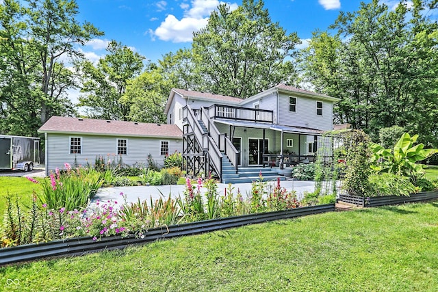 back of house with a patio area, a garden, a yard, and stairway