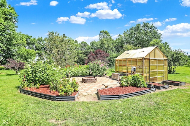 view of yard with a vegetable garden, a fire pit, an outbuilding, and an exterior structure