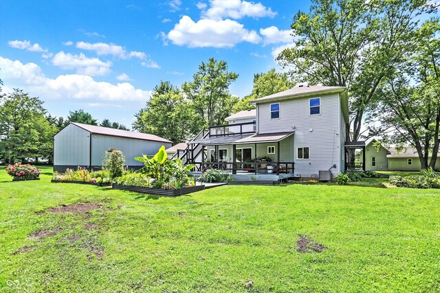 back of property with a wooden deck and a lawn