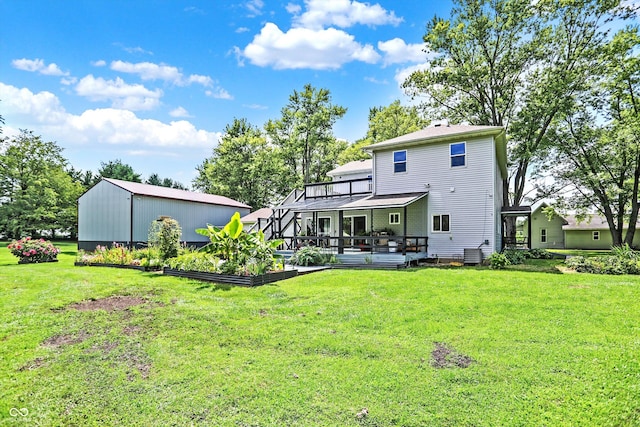 back of property featuring an outbuilding, a yard, and a deck