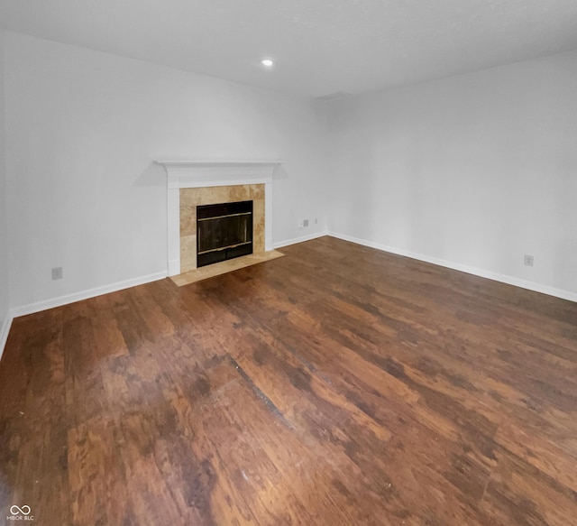 unfurnished living room featuring a fireplace and dark hardwood / wood-style floors