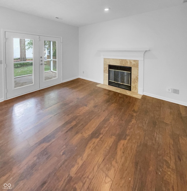 unfurnished living room with french doors, a fireplace, and hardwood / wood-style floors