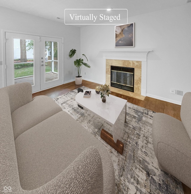 living room featuring hardwood / wood-style flooring, french doors, and a fireplace