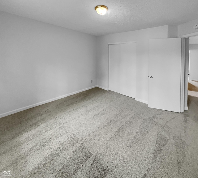 unfurnished bedroom with a closet, carpet floors, and a textured ceiling