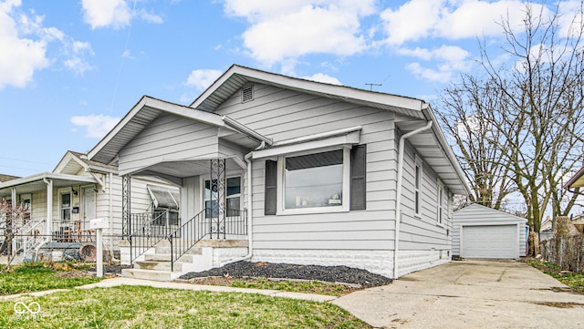 bungalow-style house featuring an outbuilding, a front lawn, a porch, and a garage