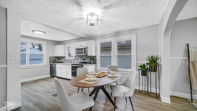 dining area featuring sink and light hardwood / wood-style flooring