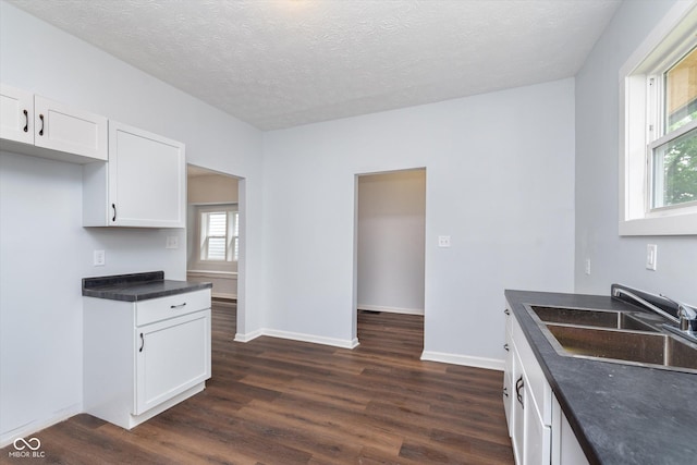 kitchen with dark hardwood / wood-style floors, sink, white cabinetry, and a textured ceiling