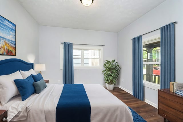 bedroom with dark hardwood / wood-style flooring and multiple windows