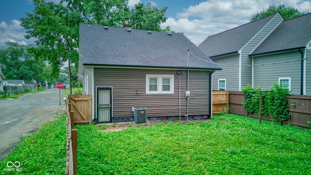 back of house featuring a lawn and central AC unit