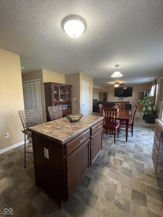 kitchen featuring tile patterned floors, a textured ceiling, and a kitchen island