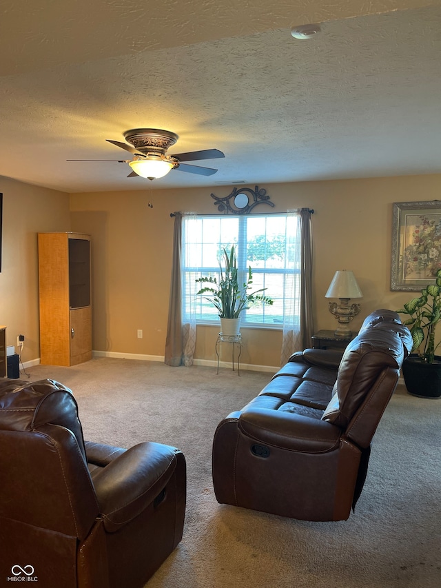 living room featuring carpet floors, a textured ceiling, and ceiling fan