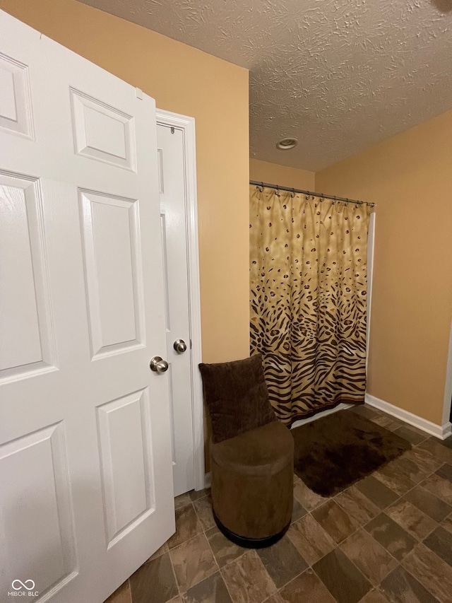 bathroom with a textured ceiling and tile patterned flooring