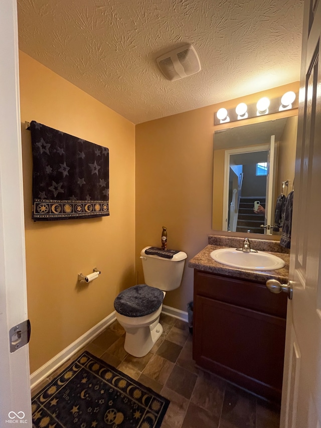 bathroom with vanity, tile patterned floors, a textured ceiling, and toilet