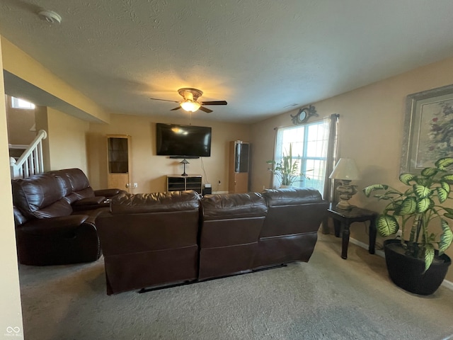 carpeted living room with a textured ceiling and ceiling fan