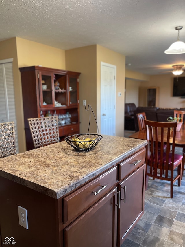 kitchen featuring a kitchen island, pendant lighting, a textured ceiling, and tile patterned floors