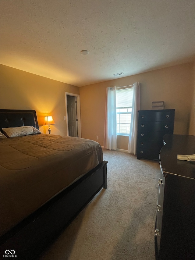 bedroom featuring a textured ceiling and carpet flooring