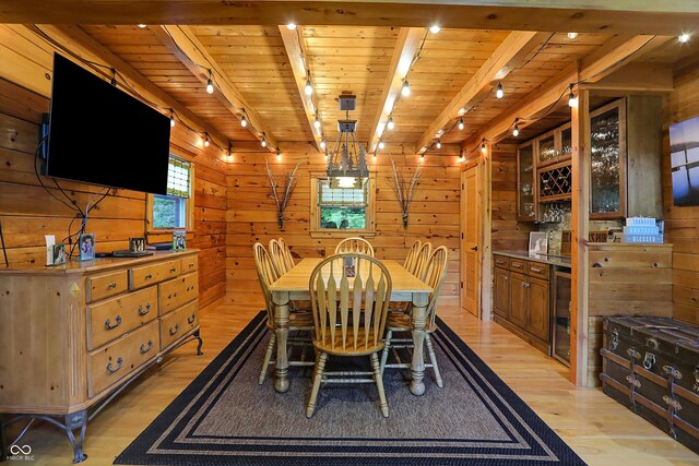 dining space with beverage cooler, wood walls, light hardwood / wood-style flooring, and wood ceiling