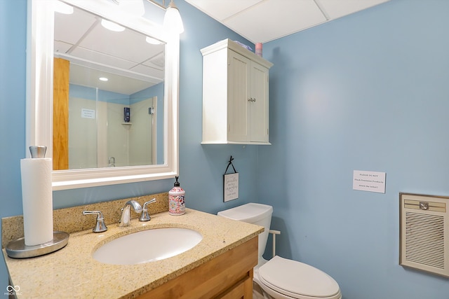 bathroom with vanity, a drop ceiling, and toilet