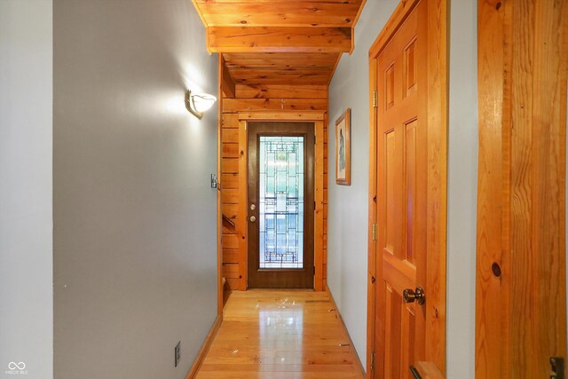 doorway featuring wood ceiling, a wealth of natural light, light wood-type flooring, and vaulted ceiling