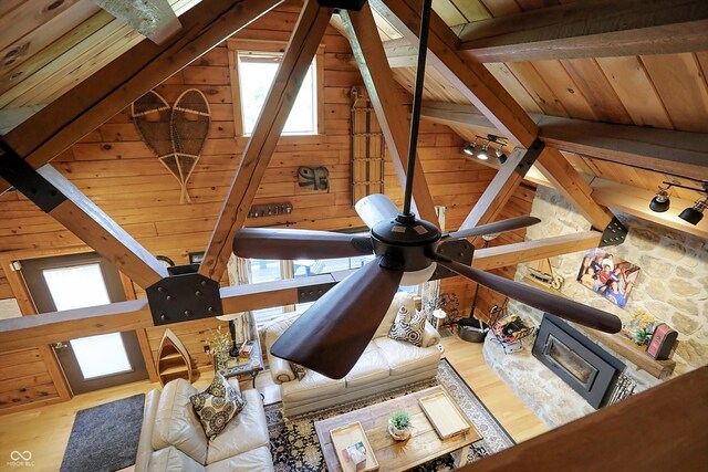 living room featuring vaulted ceiling with beams, wood ceiling, wooden walls, and hardwood / wood-style flooring