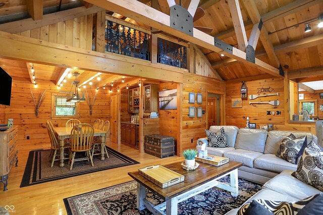 living room featuring wood walls, wooden ceiling, wood-type flooring, and beam ceiling