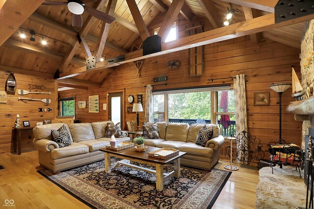 living room featuring wood ceiling, beamed ceiling, wooden walls, and light hardwood / wood-style floors