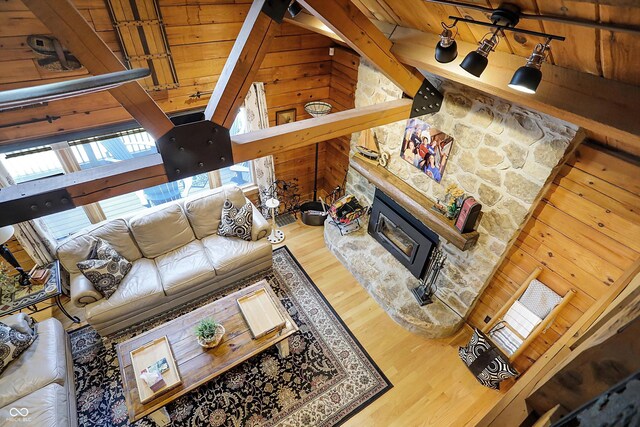 living room with wood ceiling, beamed ceiling, wooden walls, and hardwood / wood-style floors