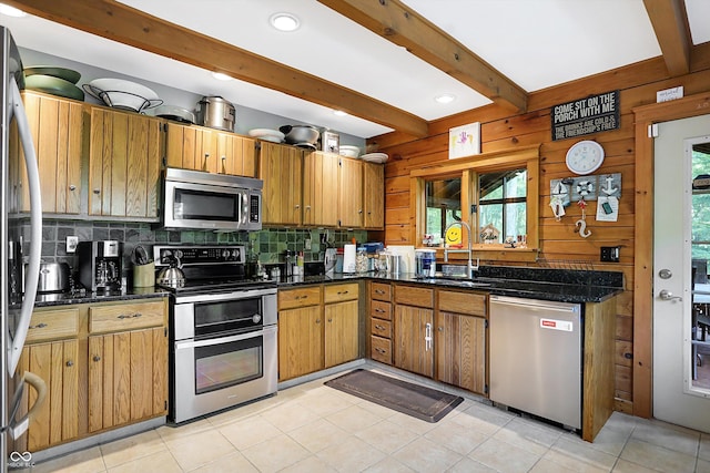 kitchen featuring beamed ceiling, appliances with stainless steel finishes, a healthy amount of sunlight, and sink