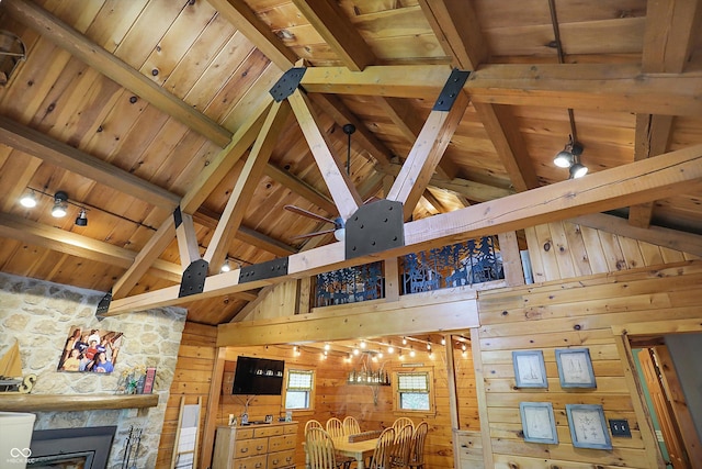 interior space featuring wood walls, wooden ceiling, rail lighting, and beam ceiling