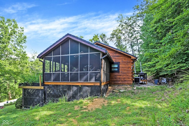 exterior space featuring a yard, a sunroom, and central AC unit