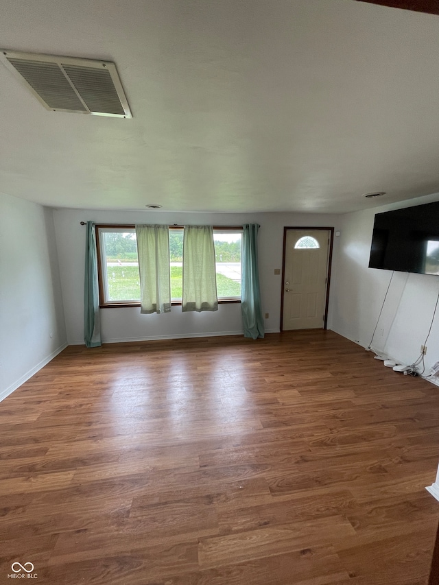 unfurnished living room featuring plenty of natural light and wood-type flooring