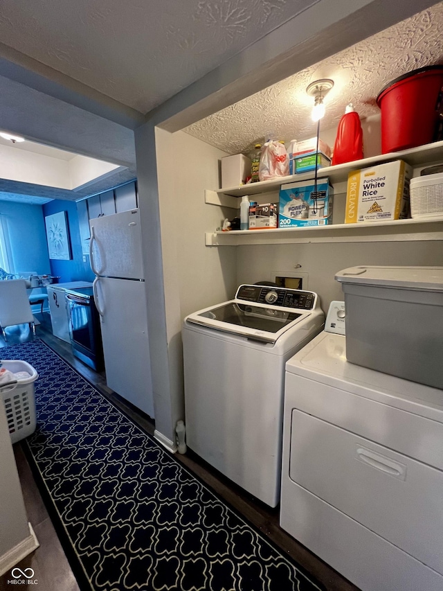 washroom with washing machine and clothes dryer and a textured ceiling