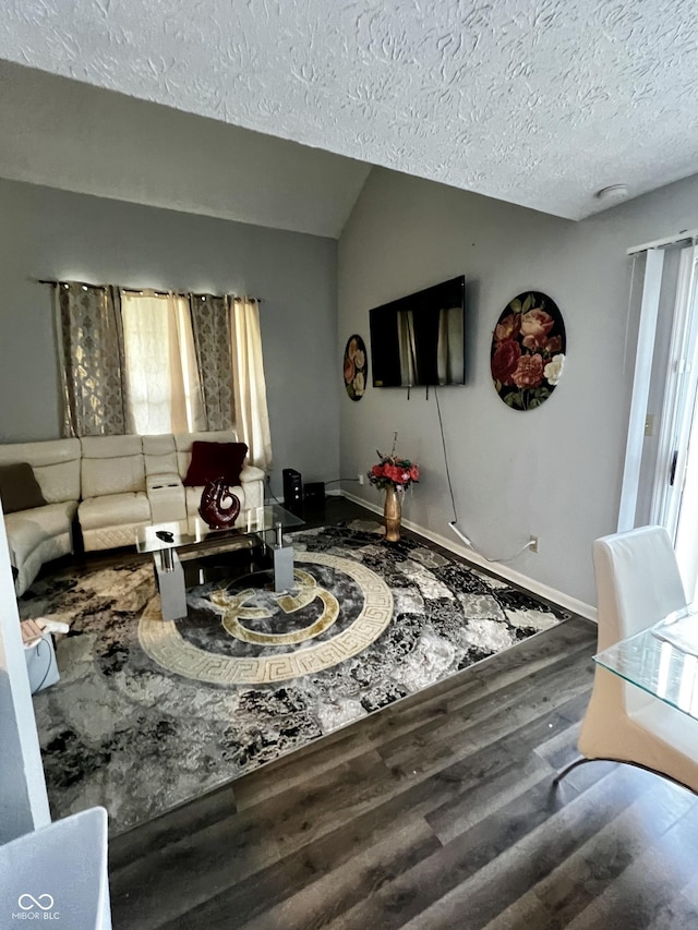 living room featuring wood-type flooring, lofted ceiling, and a textured ceiling