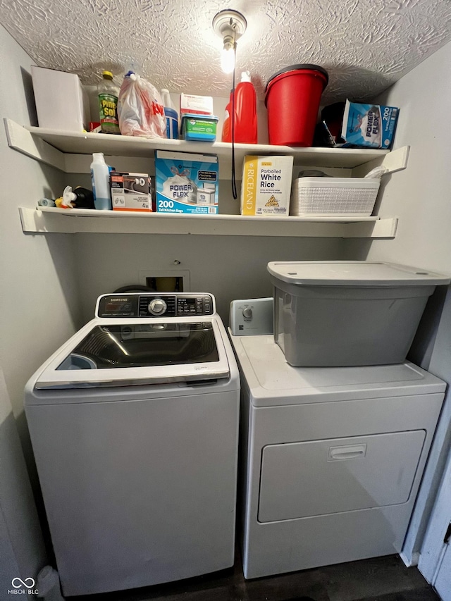 laundry area with a textured ceiling and washing machine and clothes dryer