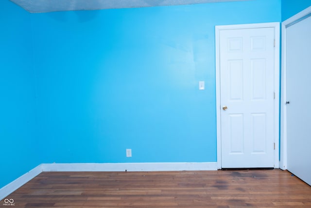 empty room featuring a textured ceiling and dark hardwood / wood-style flooring