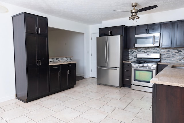 kitchen with a textured ceiling, ceiling fan, appliances with stainless steel finishes, and tasteful backsplash