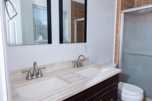 bathroom with an enclosed shower, vanity, and toilet