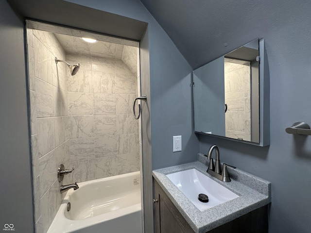 bathroom featuring vanity and tiled shower / bath