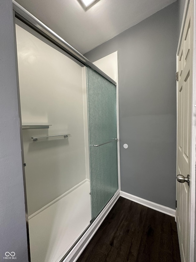 bathroom with hardwood / wood-style floors and a shower with shower door