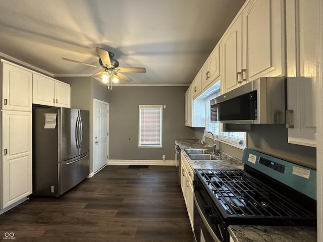 kitchen featuring ornamental molding, appliances with stainless steel finishes, sink, and white cabinets