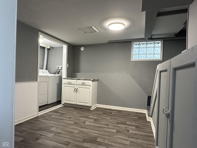 laundry area featuring cabinets, separate washer and dryer, and dark hardwood / wood-style floors