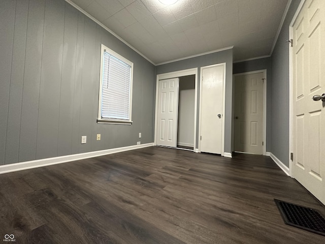 unfurnished bedroom featuring ornamental molding and dark hardwood / wood-style floors