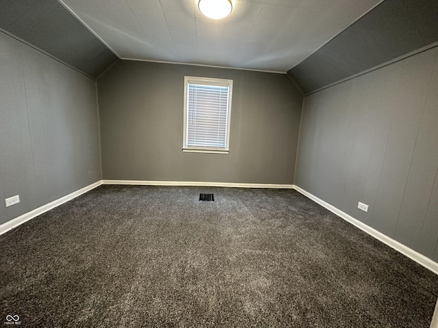 additional living space featuring carpet floors and vaulted ceiling